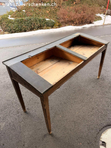 Antike Schulbank / Schultisch ca. 1900-1930 - mit Patina. Originale antike Schulbank aus Holz, vermutlich aus der Zeit ca. 1900-1930. Klassischer Schultisch mit zwei Klappdeckeln und integrierten Ablagefächern, wie sie früher in Schulzimmern verwendet wurden.
Die Tintenloch-Öffnungen sind noch sichtbar.
Der Tisch weist eine wunderschöne, authentische Patina mit altersbedingten Gebrauchsspuren auf. Die schwarze Lackierung ist teilweise stark gekrakelt, was den historischen Charakter unterstreicht.
Zustand:
• Beide originalen Klappdeckel sind vorhanden
• Die Scharniere sind ausgerissen, können jedoch fachgerecht repariert werden
• Holzsubstanz insgesamt stabil
• Alters- und Gebrauchsspuren gemäss Fotos
Ideal als Dekorationsobjekt, für ein Vintage-Interieur, Atelier, Ladenbau oder als Restaurationsprojekt für
Liebhaber alter Schulmöbel.
Masse: ca. 89 x 67 x 160