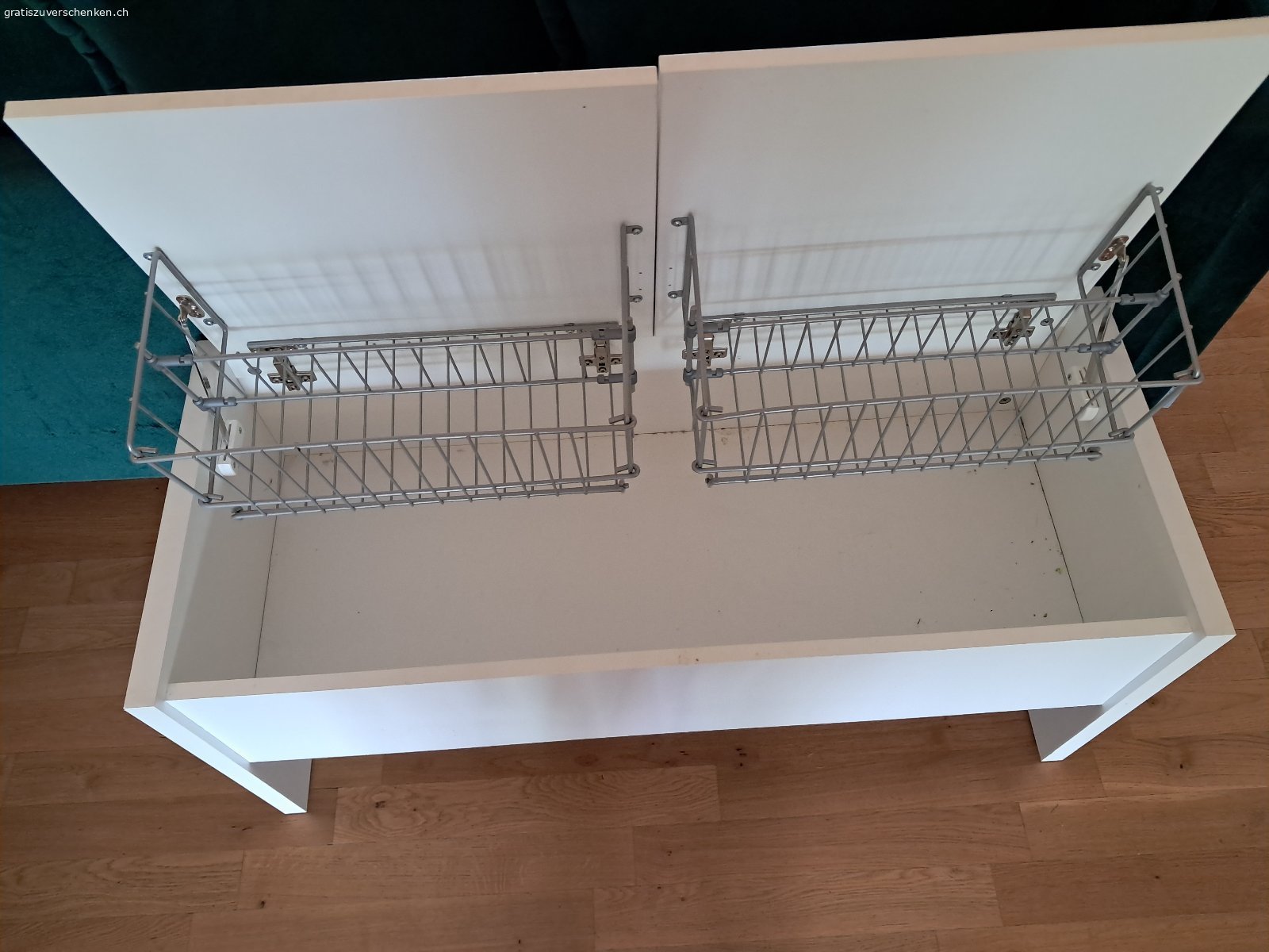 Aufklappbare Garderobensitzbank. Weisse aufklappbare Garderobensitzbank zu verschenken. Länge 1m, Höhe 45.5 cm, Tiefe 41.5 cm. Mit zwei einzeln voneinander zu öffnenden Klappen oben und Gitterhalterungen inwendig. Boden ohne Unterteilung. Muss abgeholt werden.