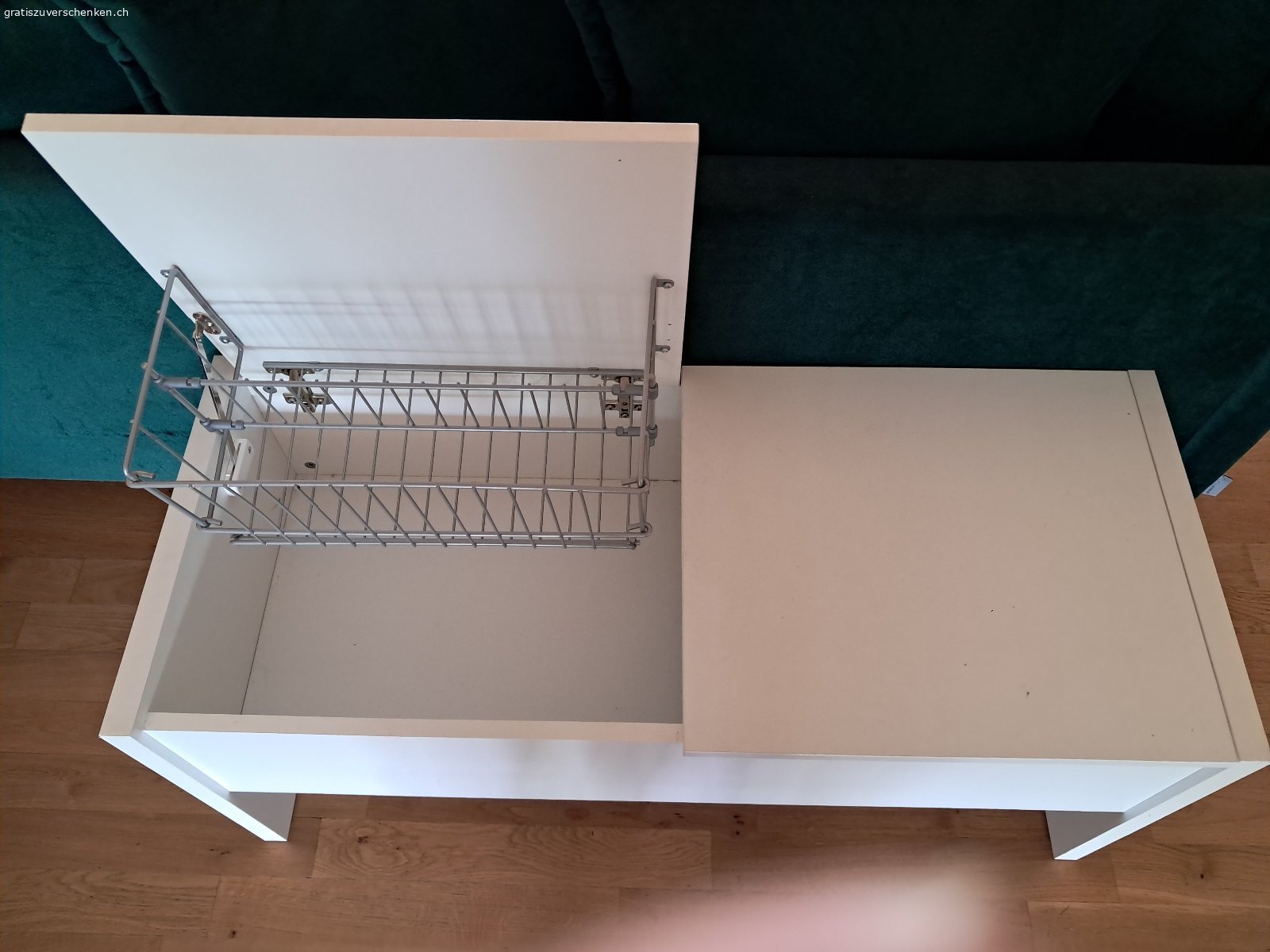 Aufklappbare Garderobensitzbank. Weisse aufklappbare Garderobensitzbank zu verschenken. Länge 1m, Höhe 45.5 cm, Tiefe 41.5 cm. Mit zwei einzeln voneinander zu öffnenden Klappen oben und Gitterhalterungen inwendig. Boden ohne Unterteilung. Muss abgeholt werden.