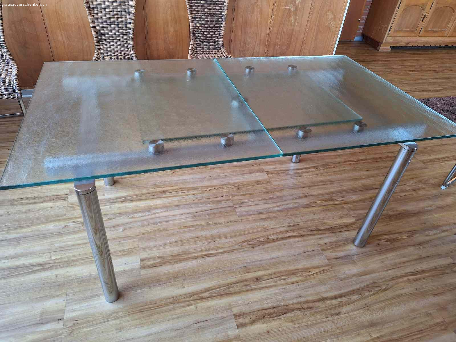 Glastisch. Glastisch zu verschenken!
 90cm x 165cm
ausgezogen: 90cm x 220cm
ACHTUNG!
Der Tisch hat einen Mangel!
Eine der 4 Halterungen die, die  ausziehbare Tischplatt stützt, war gebrochen und wurde selber repariert. Dadurch ist die Tischfläche im ausgezogenen Zustand nicht bündig (siehe Fotos). Eventuell ist jemand handwerklich geschickt und kann dieses Problem lösen.