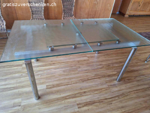 Glastisch. Glastisch zu verschenken!
 90cm x 165cm
ausgezogen: 90cm x 220cm
ACHTUNG!
Der Tisch hat einen Mangel!
Eine der 4 Halterungen die, die  ausziehbare Tischplatt stützt, war gebrochen und wurde selber repariert. Dadurch ist die Tischfläche im ausgezogenen Zustand nicht bündig (siehe Fotos). Eventuell ist jemand handwerklich geschickt und kann dieses Problem lösen.