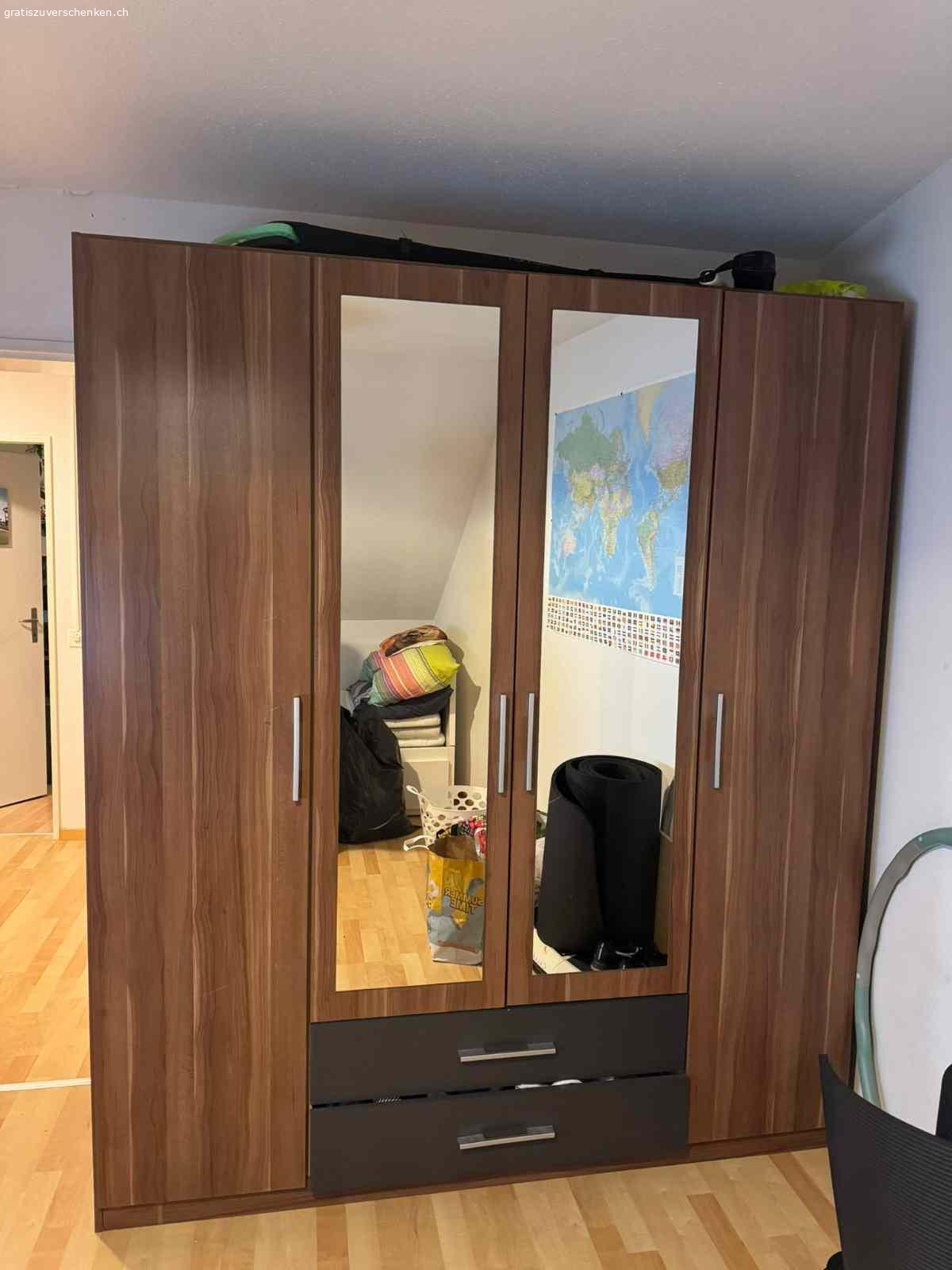 Kleiderschrank gebraucht. Wir verschenken einen gebrauchten Kleiderschrank, er hat einige kleinere Gebrauchsspuren (siehe Fotos), aber funktioniert noch einwandfrei. 
2x Spiegeltüren 
2x Fächer für Socken etc.
Mehrere Fächer und eine Stange zum Kleider aufhängen. 
Breite: 180 cm
Tiefe: 55 cm
Höhe: 210 cm 

Der Schrank befindet sich im 4.OG einer Altbauwohnung OHNE LIFT, nur Selbstabholung.