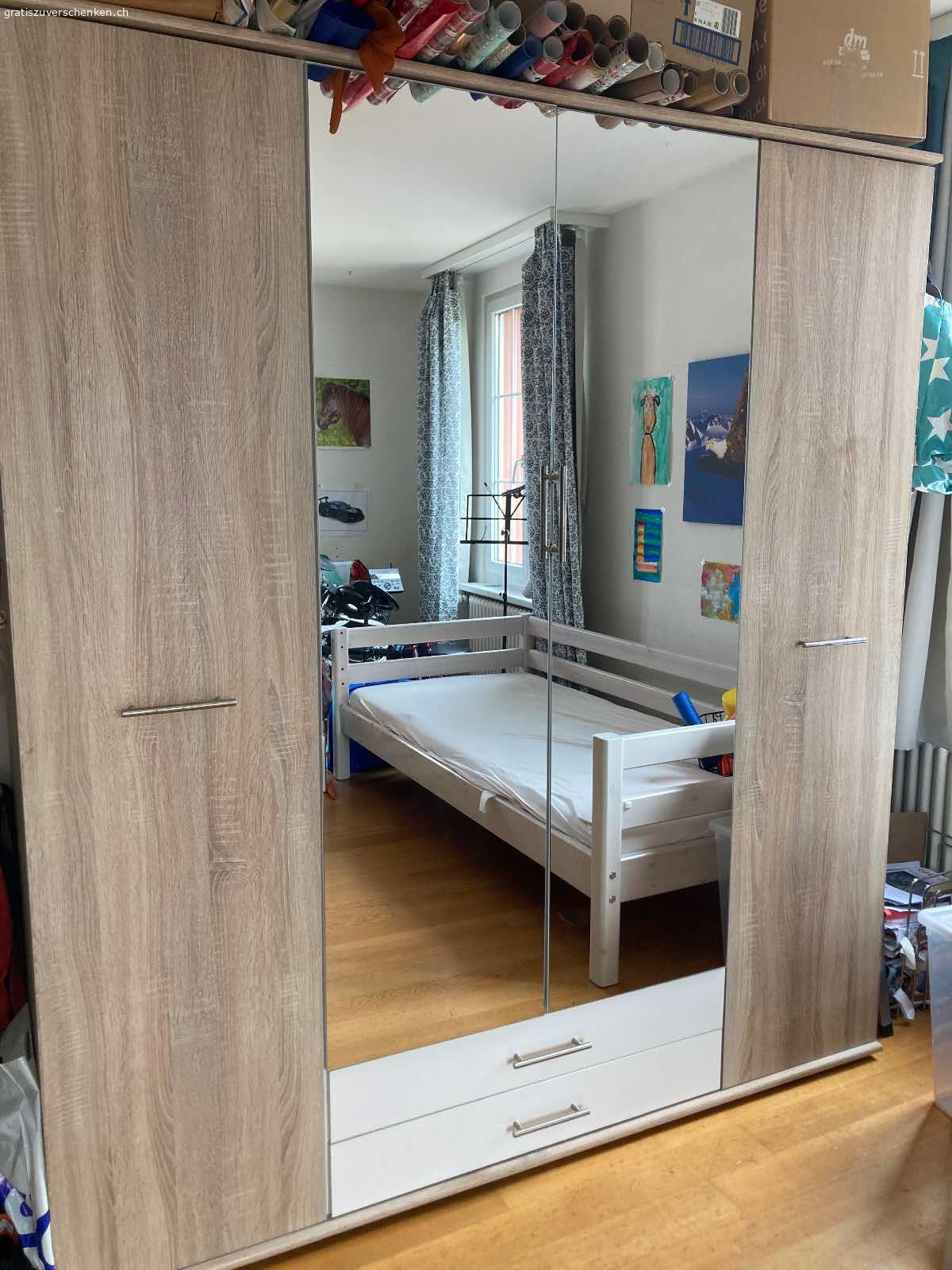 Schrank mit Spiegel. Schrank zu verschenken
4 Türen, 2 Schubladen
Maße: Breite 177 cm; Höhe 197 cm; Tiefe  56 cm
Der Schrank wurde schon mindestens zwei mal aufgebaut. Die Schubladen sind schon mal aus der Schiene gebrochen, wurden repariert und laufen jetzt wieder gut. Über der Schublade rechts ist das untere Brett etwas kaputt.
